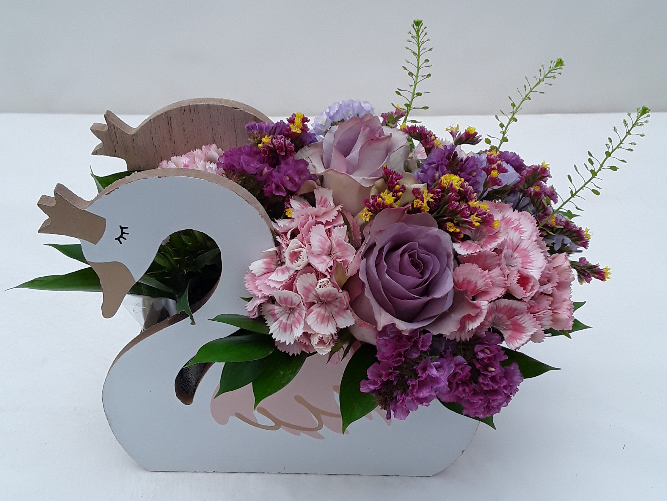 Mixed flowers in wooden swan