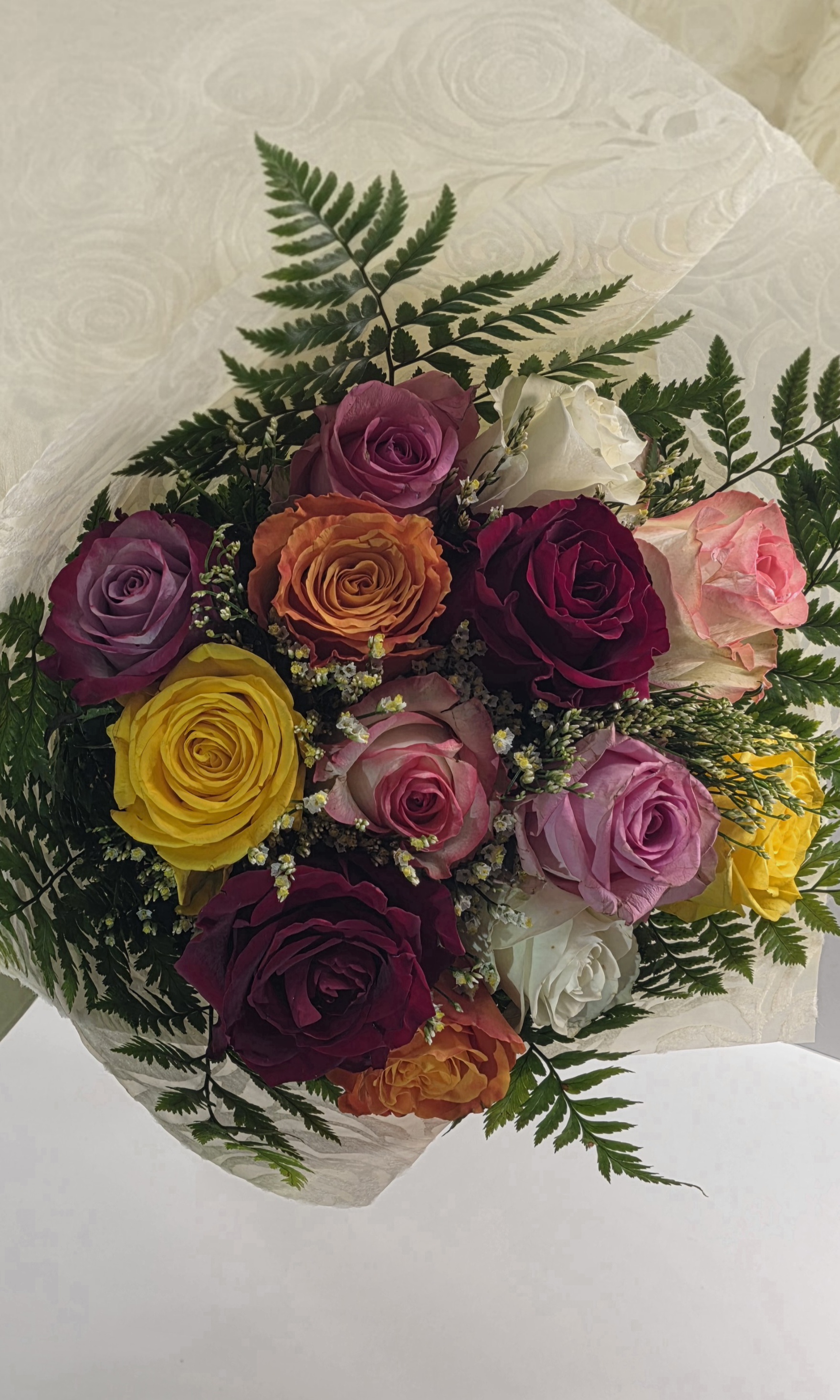 9 First Quality Multi Colour Roses With Seasonal Greenery