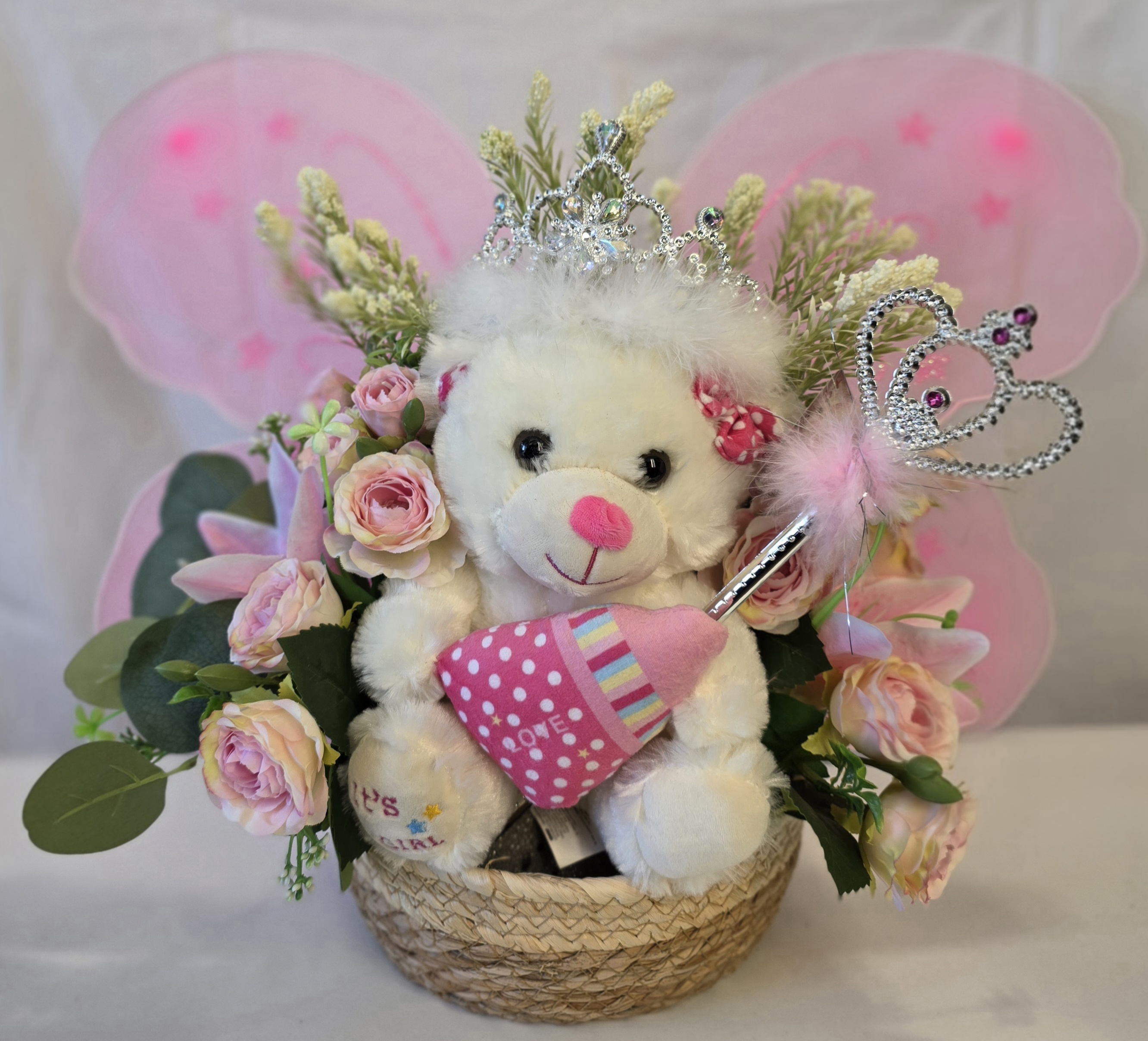 6 stem mini roses, 2 oriental lilys,1 teddy bear, seasonal greenery in a basket