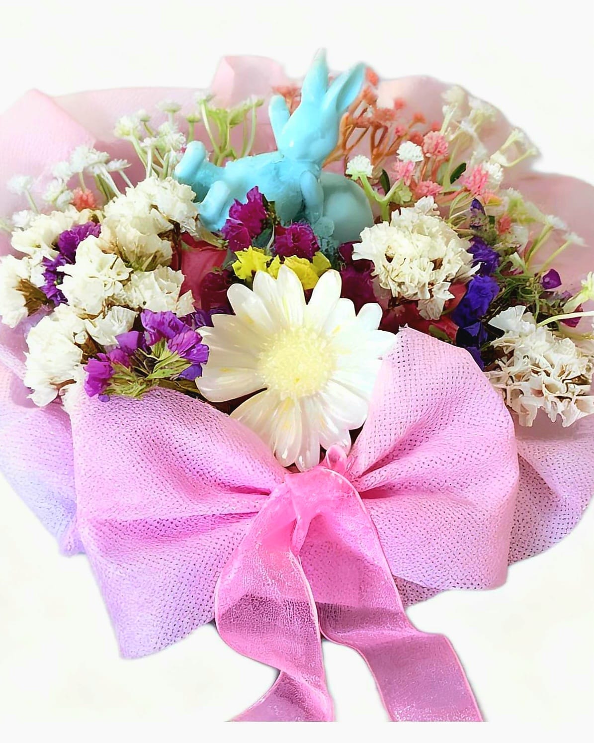 LIGHT BLUE BUNNY WITH EGG AND FLOWERS IN A BAMBOO BASKET.