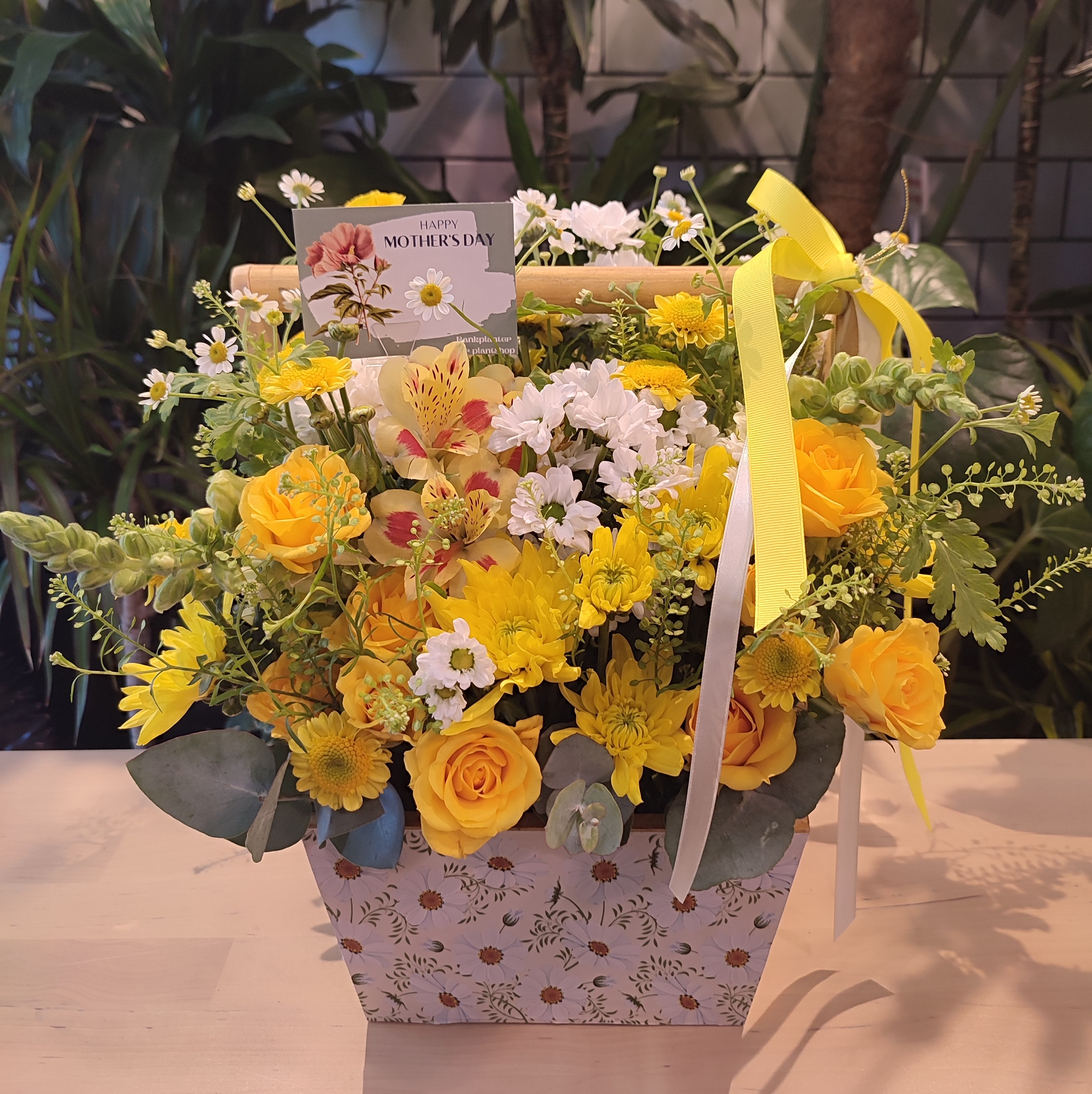 Yellow theme flower arrangement in wooden basket